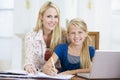 Woman helping girl with laptop doing homework Royalty Free Stock Photo