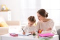 Woman helping her daughter with homework at table Royalty Free Stock Photo