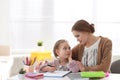 Woman helping her daughter with homework at table Royalty Free Stock Photo