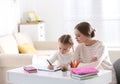 Woman helping her daughter with homework at table Royalty Free Stock Photo