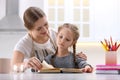 Woman helping her daughter with homework in kitchen Royalty Free Stock Photo