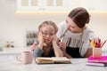 Woman helping her daughter with homework at table Royalty Free Stock Photo