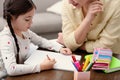 Woman helping her daughter with homework at table Royalty Free Stock Photo