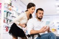 Woman helping her disabled husband to choose pharmaceuticals in drugstore Royalty Free Stock Photo