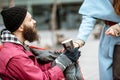 Woman giving a drink to a homeless beggar Royalty Free Stock Photo