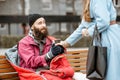 Woman giving a drink to a homeless beggar Royalty Free Stock Photo