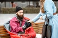 Woman giving a drink to a homeless beggar Royalty Free Stock Photo