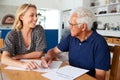 Woman Helping Senior Man To Complete Last Will And Testament At Home