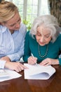 Woman Helping Senior Neighbor With Paperwork