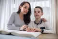 Woman helps blind boy to read a book in braille