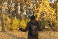 Woman with her arms outstreched enjoys in autumn as she walks through the park Royalty Free Stock Photo