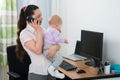 Woman With Her Baby Girl Talking On Smartphone Royalty Free Stock Photo