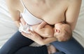 Woman in her bedroom breastfeed her baby.