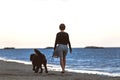 Woman with her big inseparable dog walking by the sea