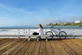 Woman with her bike on San Clemente Pier. Reading a book and  looking at the view Royalty Free Stock Photo