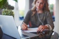 Woman at her bright cozy and beautiful home-office working on desk with laptop