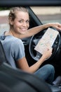 woman in car holding paper map Royalty Free Stock Photo