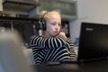 Adult woman in her casual home clothing working and studying remotely from her small flat late at night.