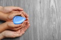 Woman and her child holding water drop on background, top view with space for text. Ecology protection Royalty Free Stock Photo