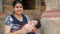 A woman with her child sits on the steps of a temple in the capital of India - Delhi