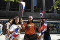 A woman and her children waving flags during the Dominican Day Parade