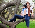 Woman and her daughter sitting on a tree Royalty Free Stock Photo