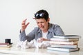 woman at her desk with books and crumpled sheets of paper. Creative crisis, learning difficulties Royalty Free Stock Photo