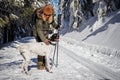 Woman with her dog hiking in winter forest Royalty Free Stock Photo