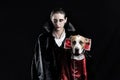 Woman and her dog in similar vampire costumes for halloween. You