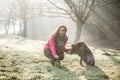 Woman and her dog stretching outdoor. Fitness girl and her pet working out together. Royalty Free Stock Photo