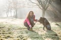 Woman and her dog stretching outdoor. Fitness girl and her pet working out together. Royalty Free Stock Photo