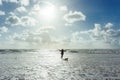 Woman and her dog walking at the beach at sunset or sunrise