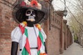 A woman with her eyes closed in white dress and Calavera Catrina sugar skull make up outdoors Royalty Free Stock Photo