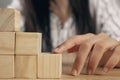 a woman with her fingers climbs a ladder of cubes