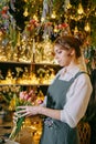 A woman in her florist shop collects bouquets of flowers. The concept of a small business. Bouquets of tulips for the Royalty Free Stock Photo