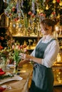 A woman in her florist shop collects bouquets of flowers. The concept of a small business. Bouquets of tulips for the Royalty Free Stock Photo