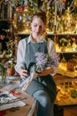 A woman in her florist shop collects bouquets of flowers. The concept of a small business. Bouquets of tulips for the Royalty Free Stock Photo