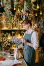 A woman in her florist shop collects bouquets of flowers. The concept of a small business. Bouquets of tulips for the Royalty Free Stock Photo