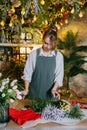 A woman in her florist shop collects bouquets of flowers. The concept of a small business. Bouquets of tulips for the Royalty Free Stock Photo