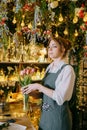 A woman in her florist shop collects bouquets of flowers. The concept of a small business. Bouquets of tulips for the Royalty Free Stock Photo