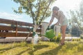 Woman in her garden watering fruit tree Royalty Free Stock Photo