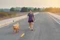 Woman with her golden retriever dog walking on the public road Royalty Free Stock Photo