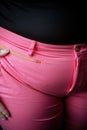 A woman with her hand on the waist of a pair of pink pants, AI