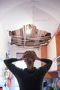 Woman with her hands on her head comes home to find that the kitchen ceiling has collapsed