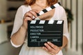 A woman in her hands holds a black board with a clapperboard while shooting a film, video. Cinema tablet in video production. Take Royalty Free Stock Photo