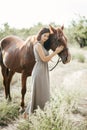 Woman with her horse on a lovely meadow lit by warm evening light. Animal love concept Royalty Free Stock Photo