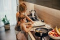 A woman and her little daughter bond while preparing small cabbage pies in the kitchen