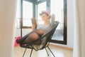 Woman in her living room relaxing reading a book