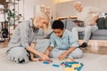 Woman and her multiracial son sitting at the carpet and putting jenga Royalty Free Stock Photo