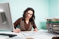 Woman at her office with blueprints in front of her Royalty Free Stock Photo